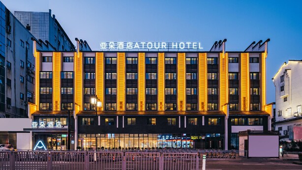 A hotel with a modern facade, multiple floors, and illuminated signage. - Atour Hotel Nankong Quzhou (Quzhou)