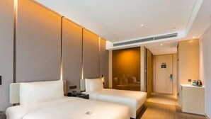 A hotel room with two beds, a desk, and a mirror. - Atour Hotel (Suzhou)