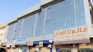 A commercial building with multiple storefronts, including a visible sign for 'Pioneers World' and other businesses.
