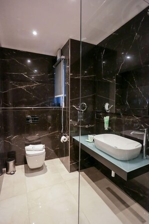 A modern bathroom with a glass-enclosed shower, a white sink, and a toilet. - J me Boutique - Adults Only (St. Julian's)