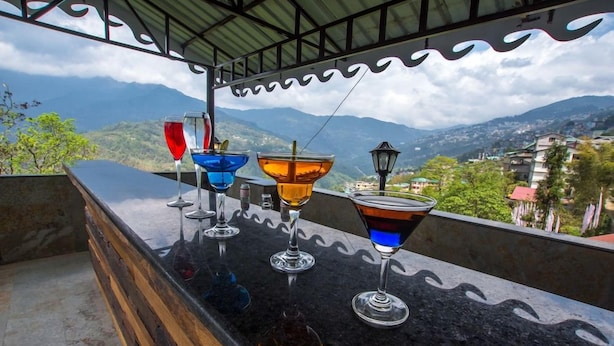 A bar with a view of mountains and a town. - Mount Himalayan Hotel & Spa Gangtok (Gangtok)