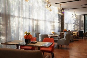 A modern dining area with tables, chairs, and decorative lighting.