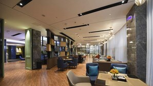 A modern hotel lobby with a wooden floor, seating areas, and a bar. - Echarm Hotel Huaihua Hexi Longping Guoji (Huaihua)