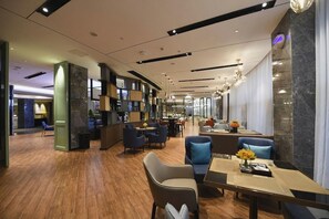 A modern hotel lobby with a wooden floor, seating areas, and a bar. - Echarm Hotel Huaihua Hexi Longping Guoji (Huaihua)