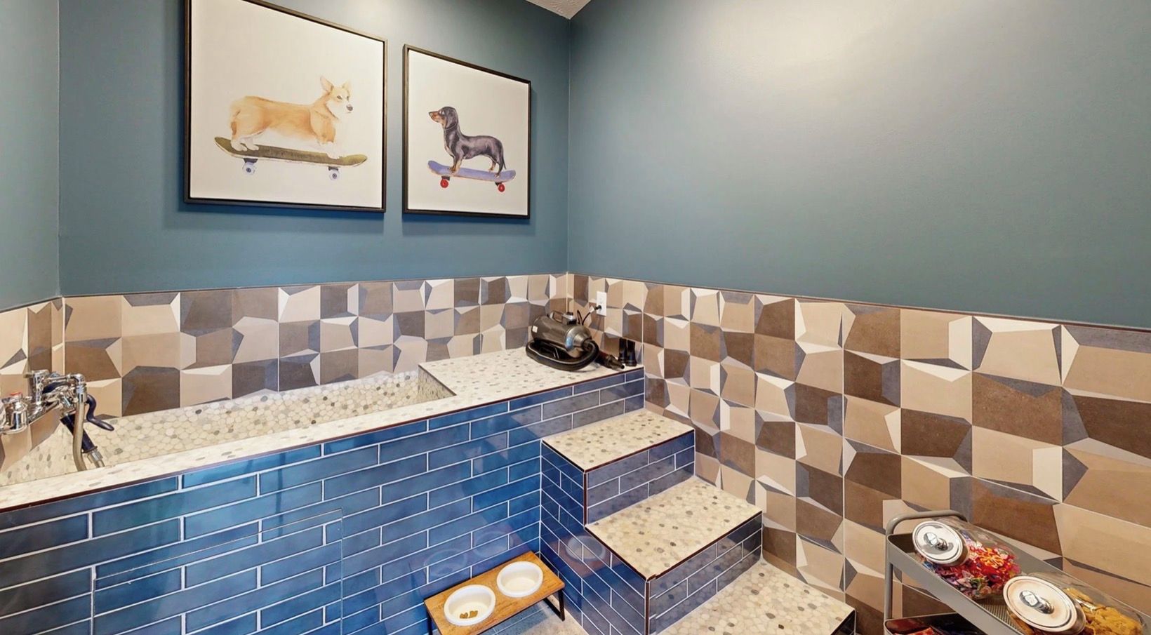 Un baño con pared de azulejos azules, un lavabo y un bebedero para perros.