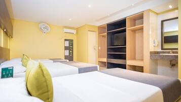 Habitación de hotel con dos camas, un armario, un televisor y baño con lavamanos.
