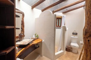 Een badkamer met een houten plank, toilet en een douche.