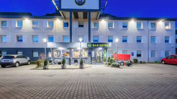 Ein Bed and Breakfast Hotel mit befestigtem Eingangsbereich, zahlreichen Fenstern und einem Schild.