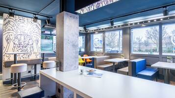 Ein modernes Interieur mit einer langen Theke, einer Sitzecke und großen Fenstern.