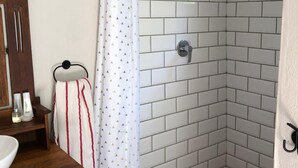 A corner shower with white tiled walls and a showerhead. - Tegwaan Country Getaway (Emgwenya)