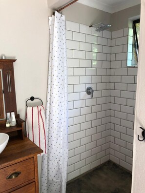 A corner shower with white tiled walls and a showerhead. - Tegwaan Country Getaway (Emgwenya)