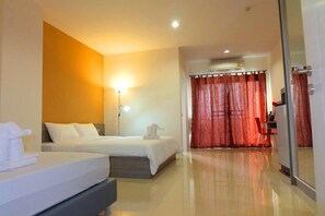 A hotel room with two beds, a desk, a chair, and a large mirror. - The Pride Salaya (Sam Phran)