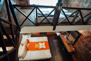 Una habitación de hotel con una cama, una mesa de madera y vistas al exterior.
