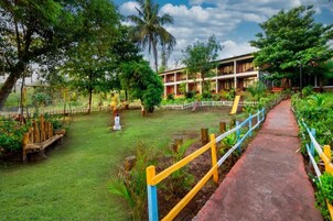 Un hotel con jardín, un sendero y un edificio de varios pisos.