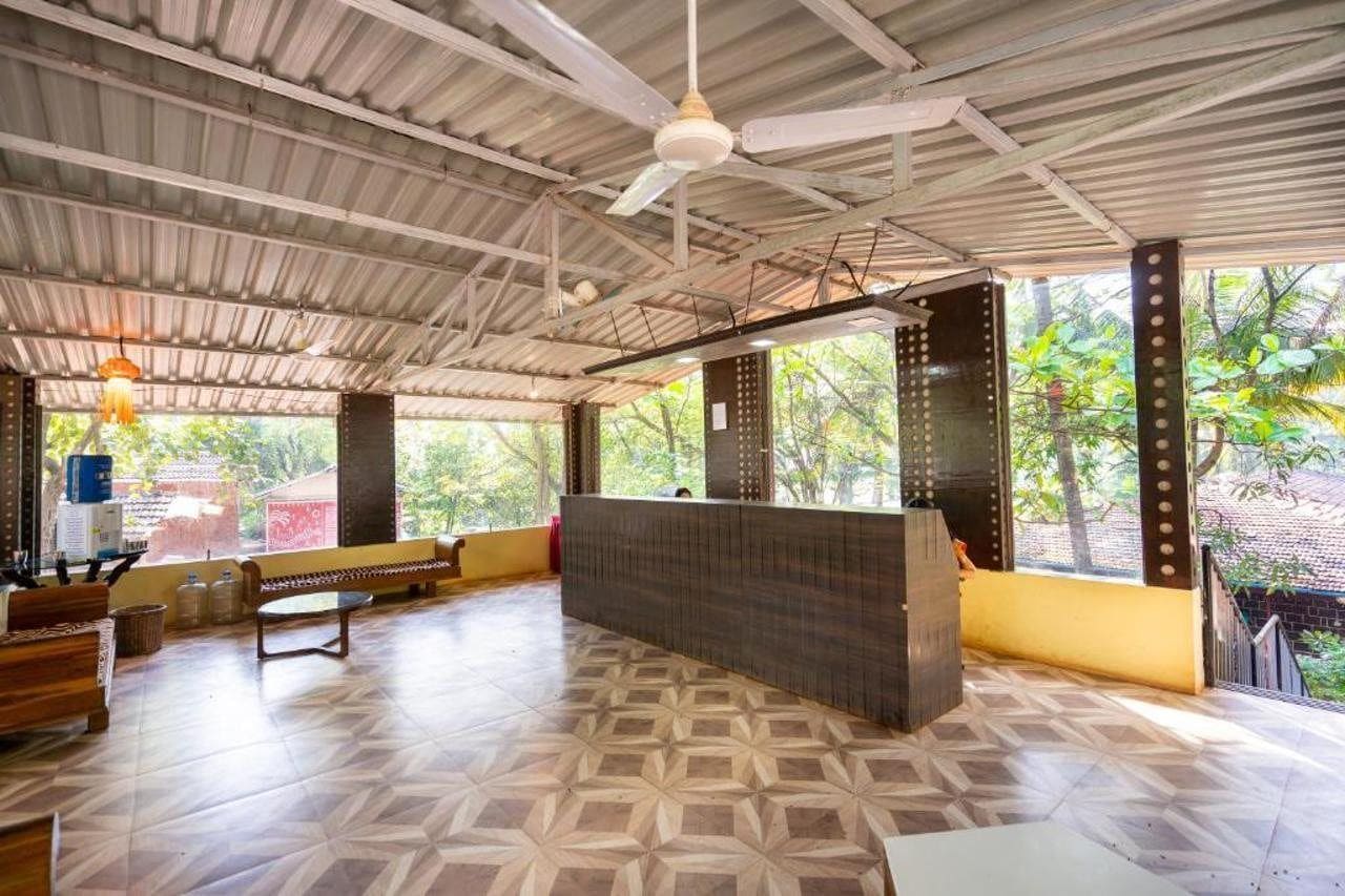 A reception area with a counter, seating, and a view of greenery outside.