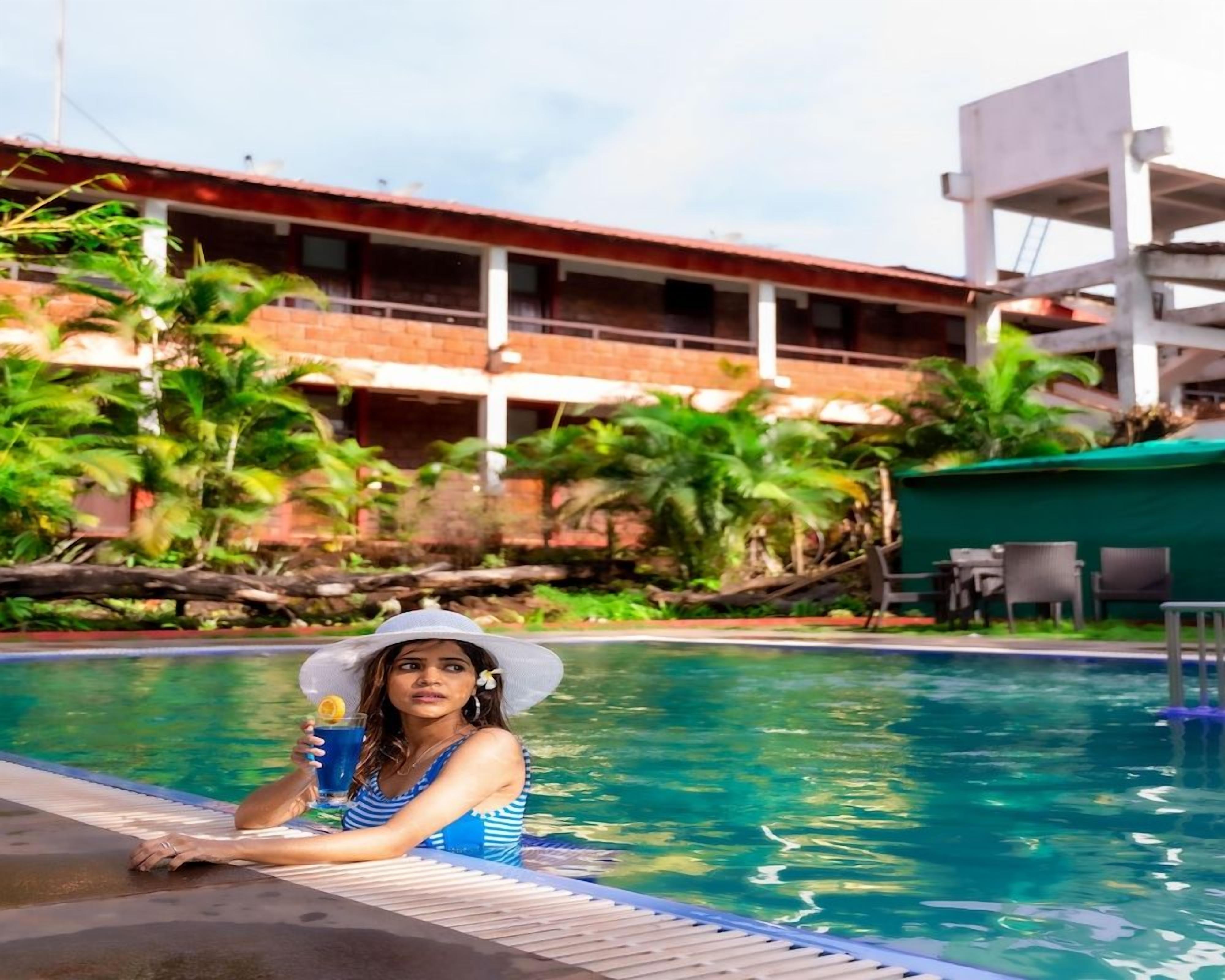 A person relaxing by a pool with a building in the background.