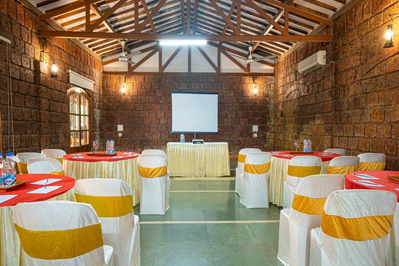 A conference room with a stage, tables, and chairs arranged for an event.