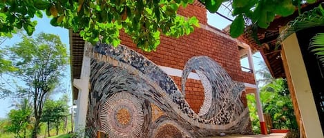 Ein Gebäude mit einer Mosaikwand und Stufen, die zu einem überdachten Eingang führen.