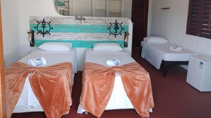 Ein Hotelzimmer mit zwei Betten, einem kleinen Schreibtisch und einer Tür mit der Aufschrift 'SAIDA'.