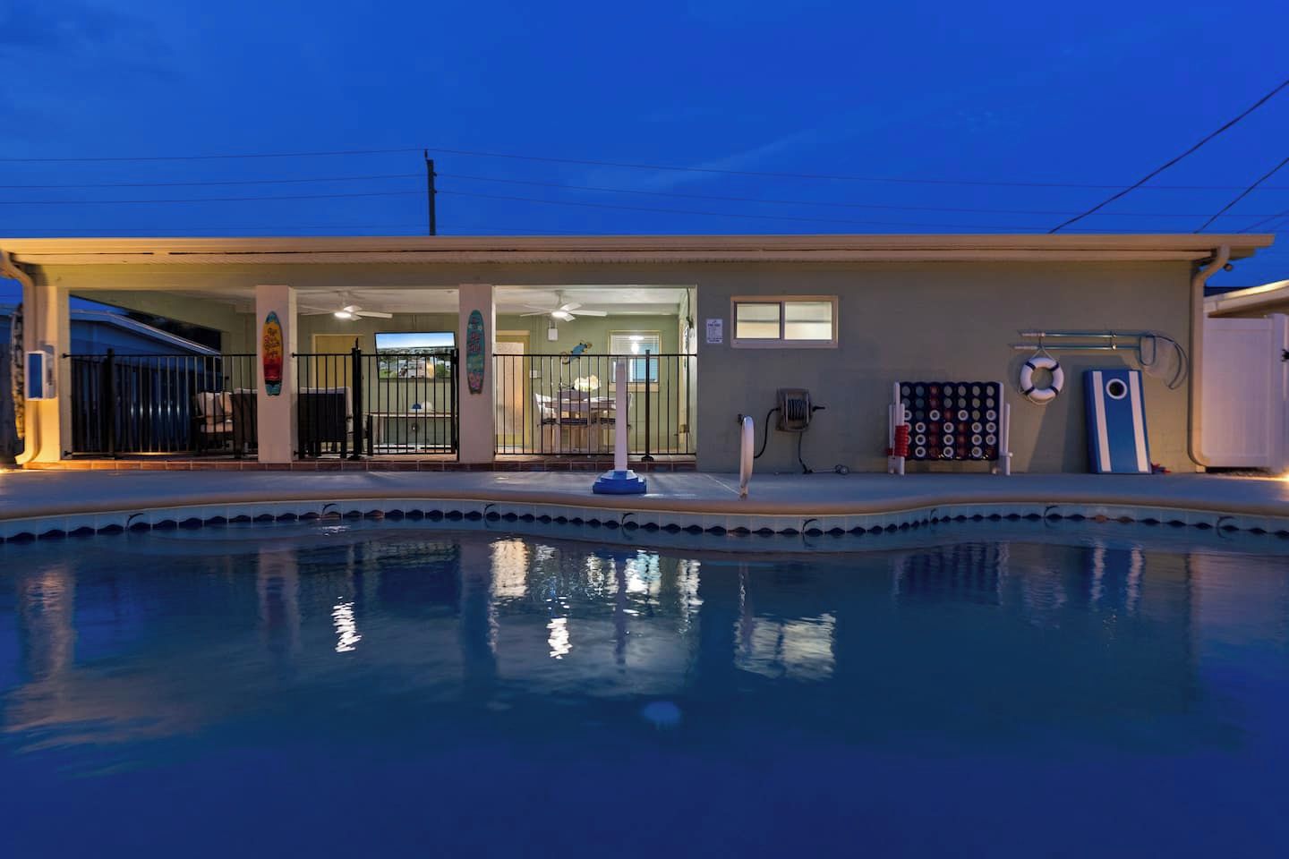 A swimming pool area with a covered entrance, a lifebuoy, and a paddle board.
