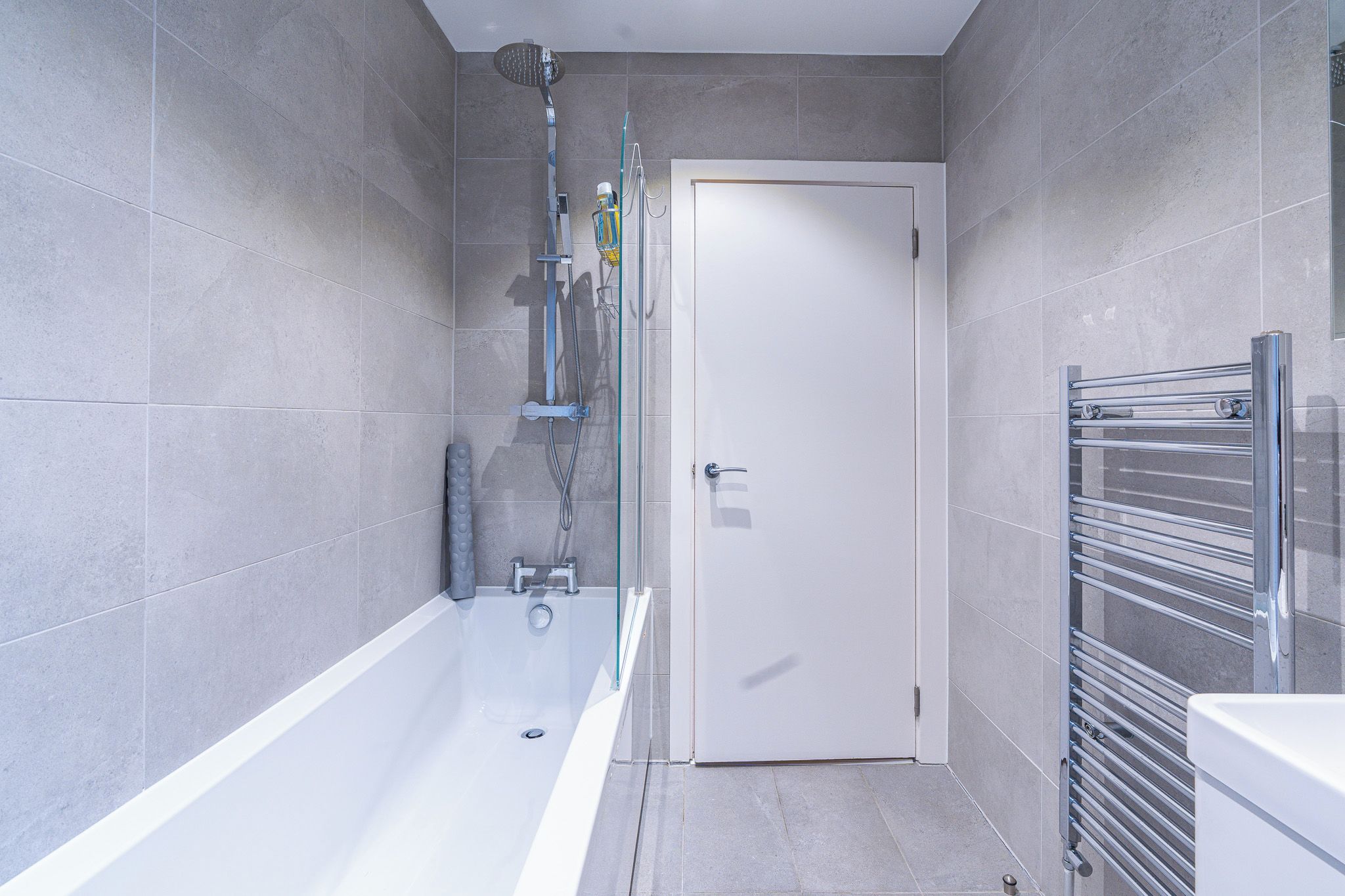 Ein modernes Badezimmer mit Badewanne, Dusche und einer gläsernen Duschkabine.