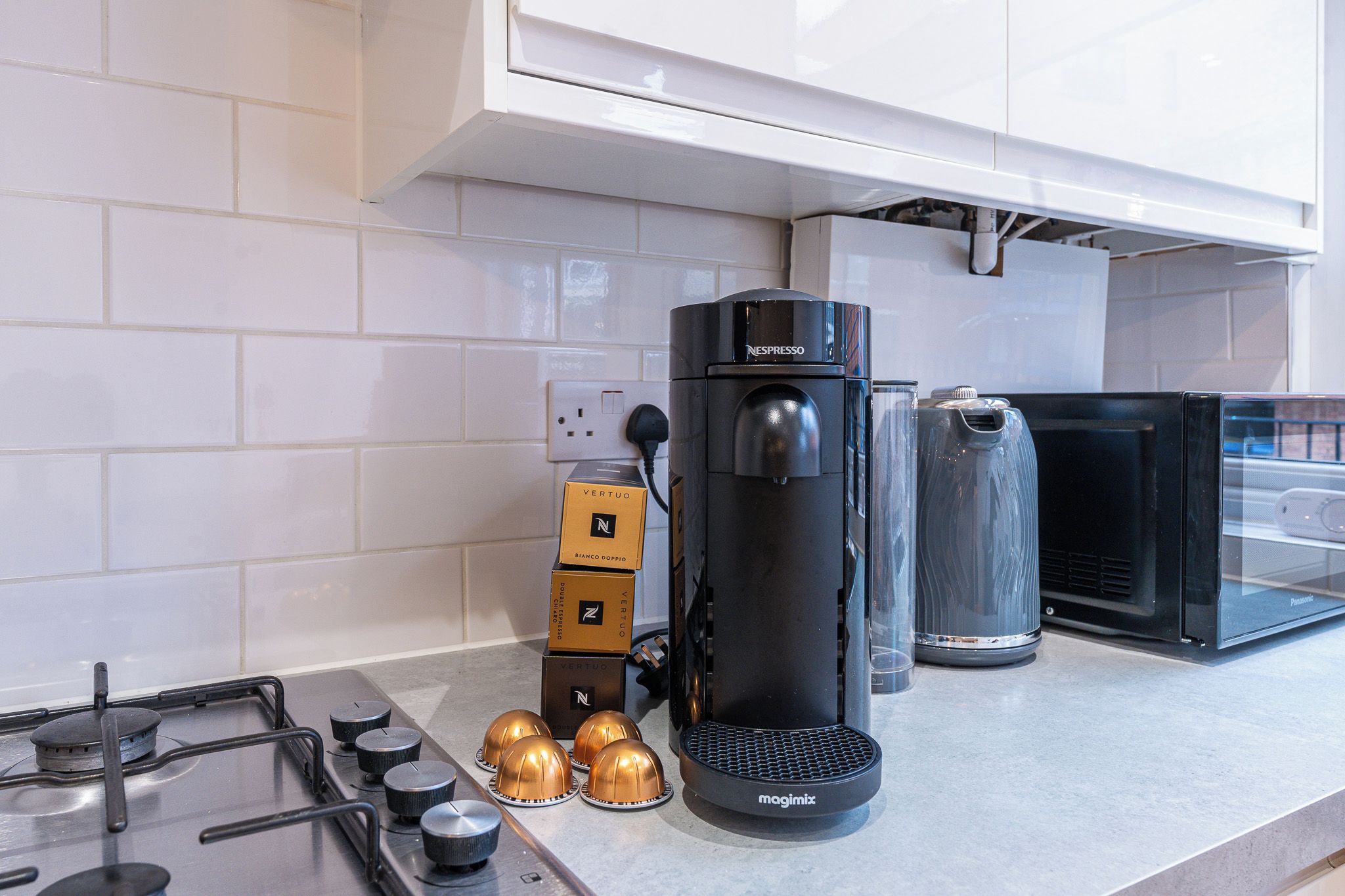 A kitchen with a coffee machine, a toaster, and a stove.
