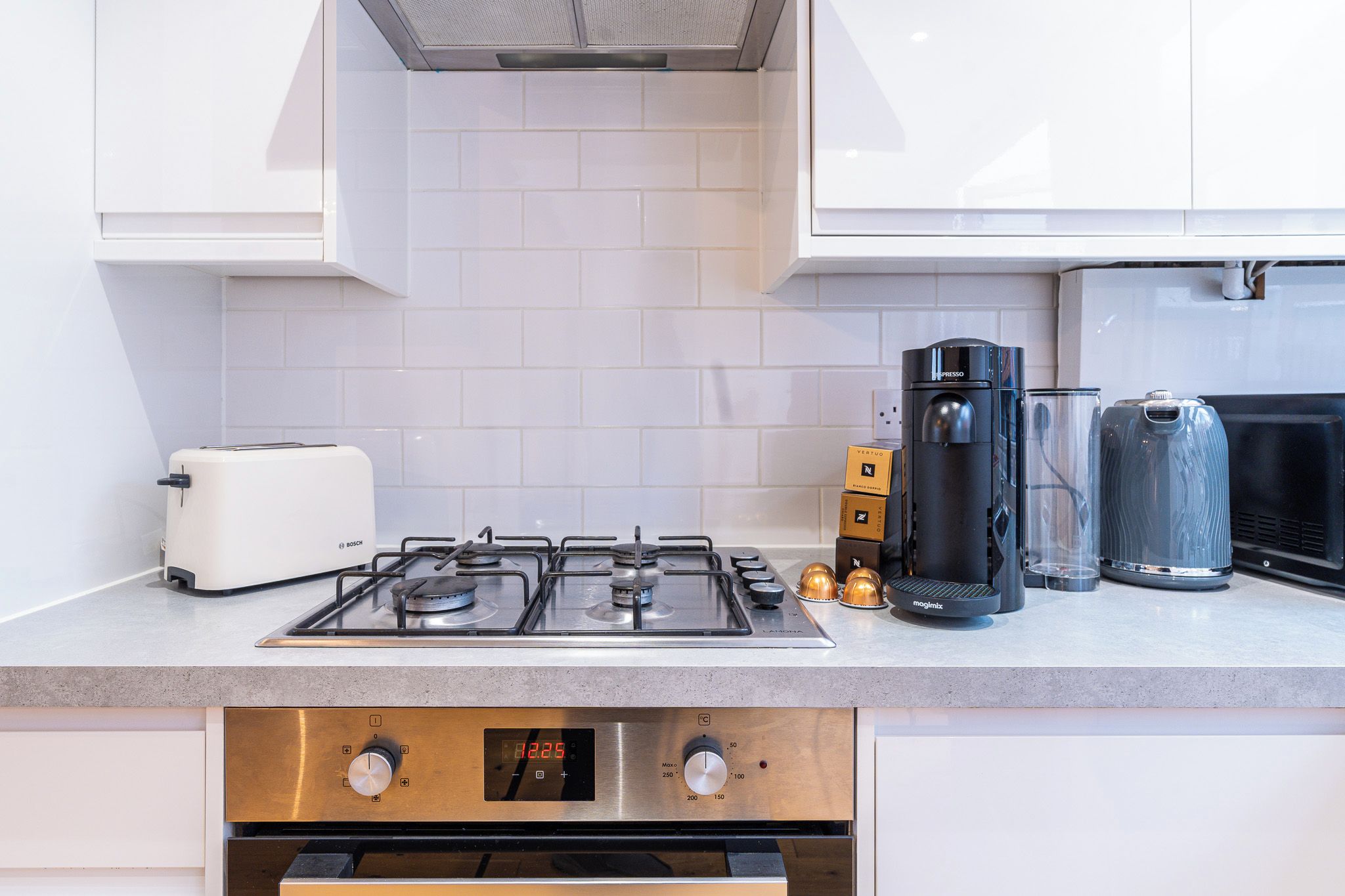 Una cucina moderna con un tostapane Bosch, una macchina da caffè e un piano cottura.