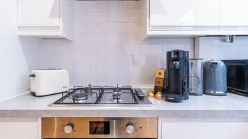 Una cucina moderna con un tostapane Bosch, una macchina da caffè e un piano cottura.