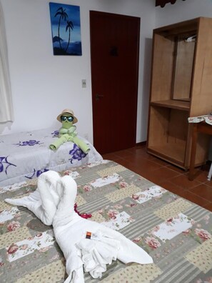 Una stanza con un letto, un armadio in legno, una porta e un quadro appeso al muro.