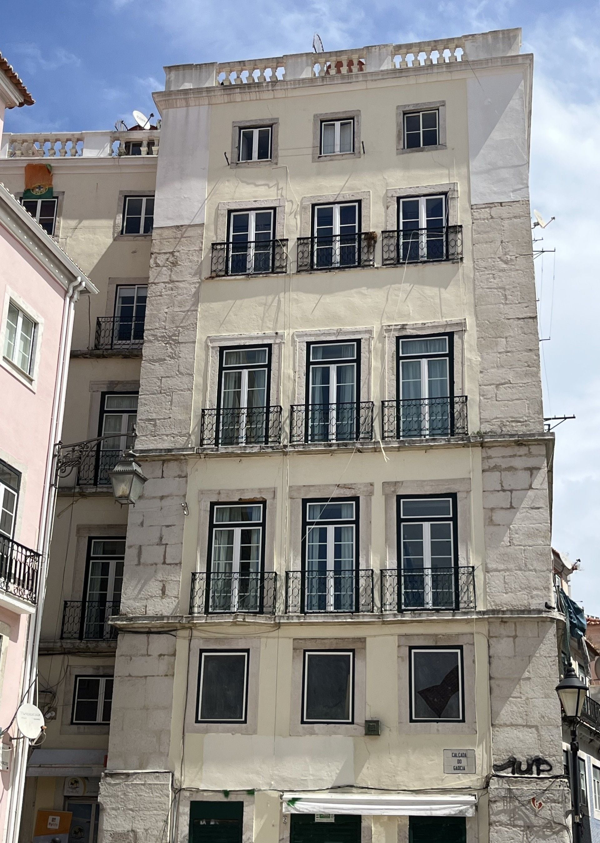 A multi-story building with balconies, windows, and a sign indicating a laundry service.