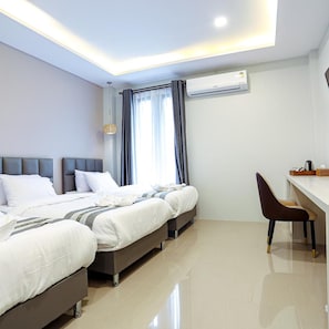 A modern hotel room with a large bed, a desk, and an air conditioning unit. - Worachat Boutique Hotel (Wang Thong)