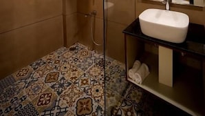 Ein Badezimmer mit Dusche, Waschbecken und Spiegel.
