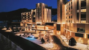 A modern hotel with a pool area, multiple buildings, and a mountainous backdrop. - Courtyard By Marriott Chongli (Zhangjiakou)
