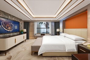 A modern hotel room with a large bed, a television, a desk, and a view of the outdoors. - Vienna Hotel (Kunming)