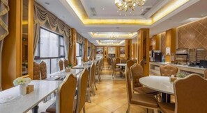 A long dining table with chairs, a chandelier, and a view of the street. - Vienna Hotel (Kunming)
