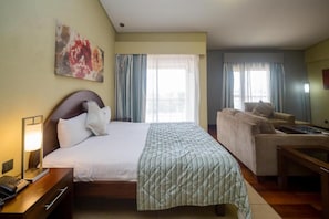 Habitació d'hotel amb llit, escriptori, sofà i un quadre a la paret.