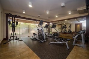 A gym with various exercise equipment, including treadmills, stationary bikes, and weight machines. - Taarifa Suites (Nairobi)