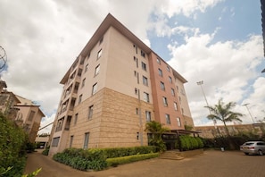 A multi-story residential building with a central courtyard, balconies, and a gated entrance. - Taarifa Suites (Nairobi)