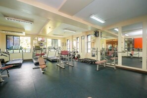 A gym with various exercise equipment, large windows, and mirrors. - Kengen RBS Gardens Apartments (Nairobi)