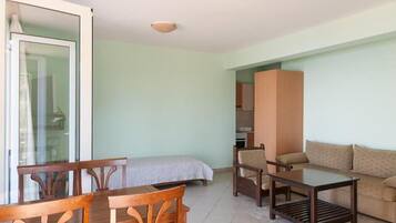 Um quarto com cama, sofá, mesa e cadeira.