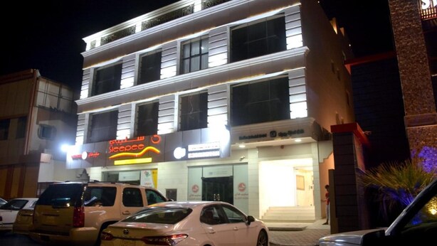 A multi-story hotel with a prominent sign for a restaurant. - Salsbil Almasi (Madinah)