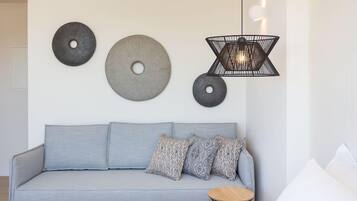 A modern living room with a grey sofa, patterned cushions, and a small round table.