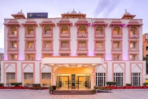 Un hotel de varios pisos con un estilo arquitectónico tradicional, que cuenta con balcones y una entrada central.