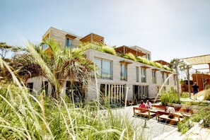 Een modern gebouw met een plat dak, grote ramen en een dakbostuin.