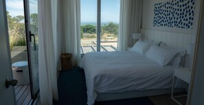 Una camera d'albergo con un letto, vista sull'esterno e una finestra con tende.