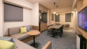 A compact living space with a sofa, a dining table, and a kitchen area. - Minn Kappabashi (Tokyo)