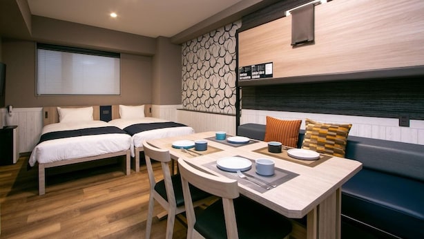 A compact room with two beds, a dining table, and a seating area. - Minn Kappabashi (Tokyo)
