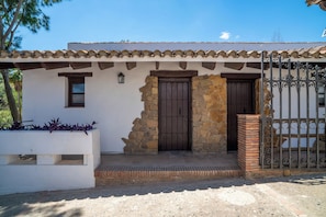 A building with a stone facade, a tiled roof, and a metal gate. - Malaga Sierra de las Nieves by Real Spain Hotels (Casarabonela)