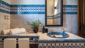 A bathroom with blue and white tiles, a sink, a mirror, and a potted plant. - Malaga Sierra de las Nieves by Real Spain Hotels (Casarabonela)