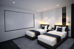 Habitación de hotel con dos camas, un televisor grande de pared y una ventana con cortinas.